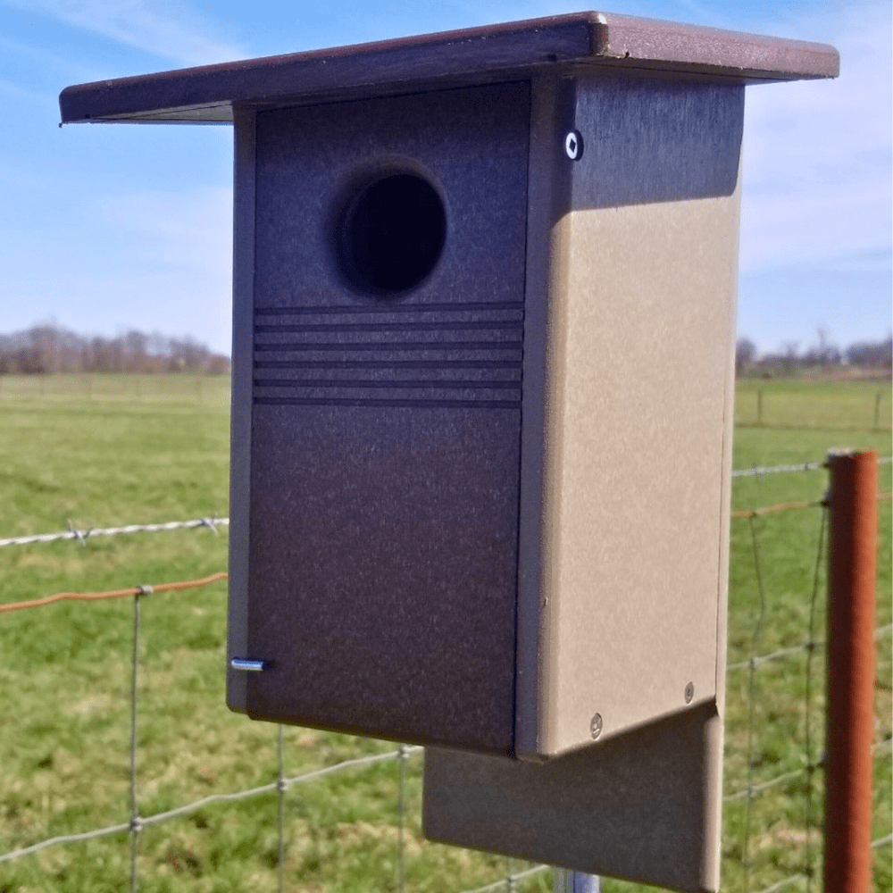 Birdhouse in a grassy field and blue sky in the background