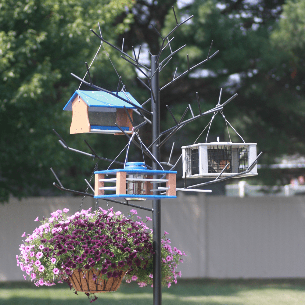 Decorative Multi-Feeder tree with Bird feeders and a flower basket attached to a tree with a blurred background