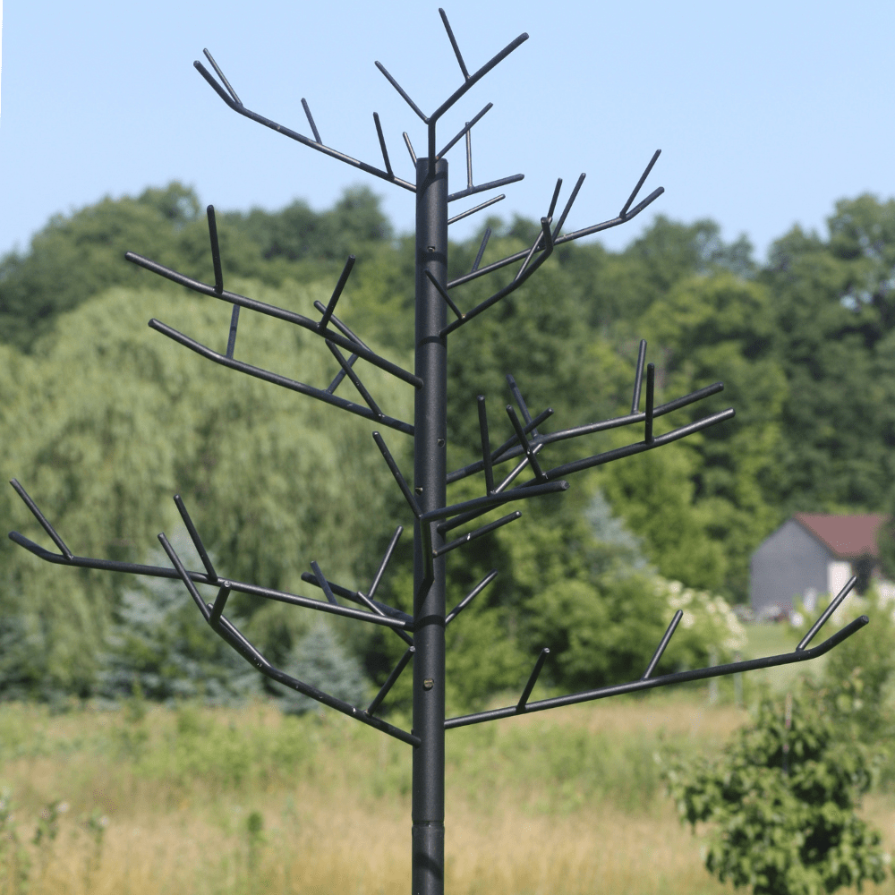 Decorative Multi-Feeder tree sculpture against a natural background with trees and a house.