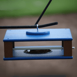 Gilbertson classic bird feeder hanging against a blurred green and brown background